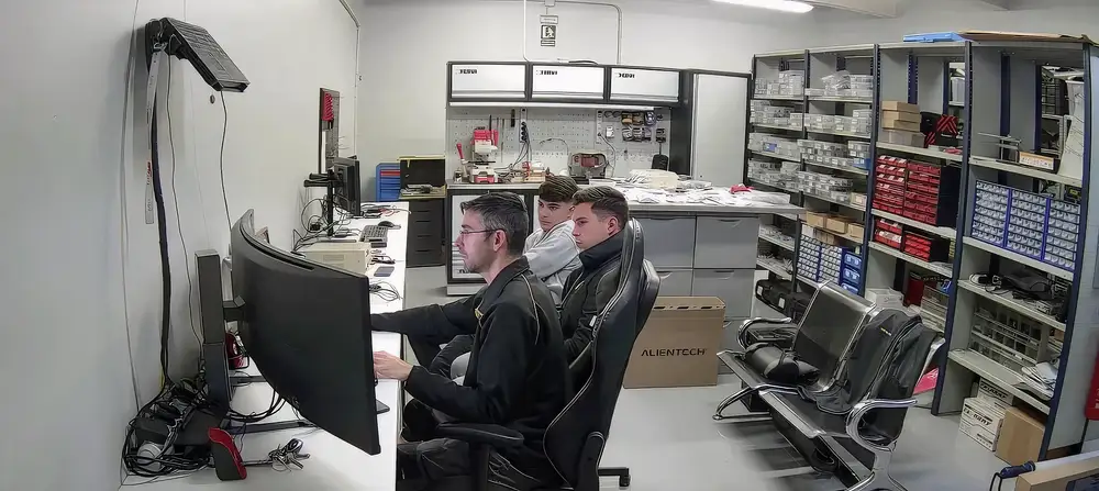 El cliente sentado al lado del programador, los dos mirando la pantalla del ordenador con la gráfica de potencia del coche.